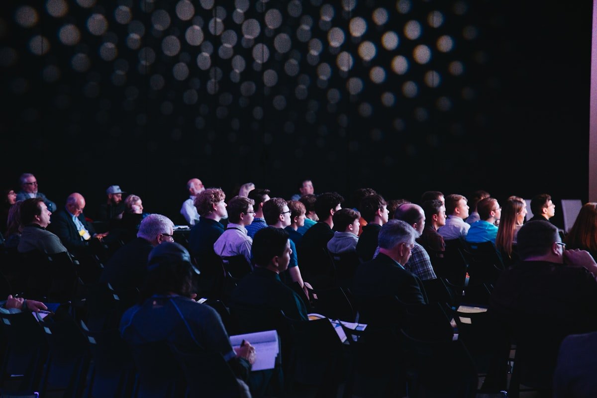 Conference attendees gathered in a bright presentation hall